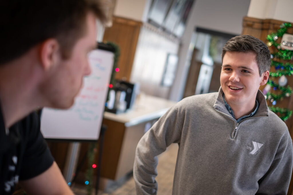 Photo of UW-Green Bay Masters of Public Administration student Gage Beck speaking with a co-worker at the Greater Green Bay YMCA. Photo by Dan Moore, University Photographer