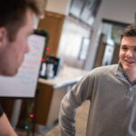 Photo of UW-Green Bay Masters of Public Administration student Gage Beck speaking with a co-worker at the Greater Green Bay YMCA. Photo by Dan Moore, University Photographer