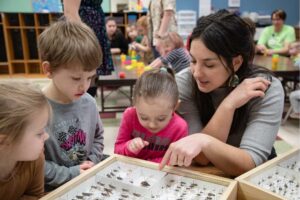 Photo of graduate students from Professor Barrett Klein's biology lab sharing a lesson on insects with children from Red Balloon Early Learning Center in La Crosse.