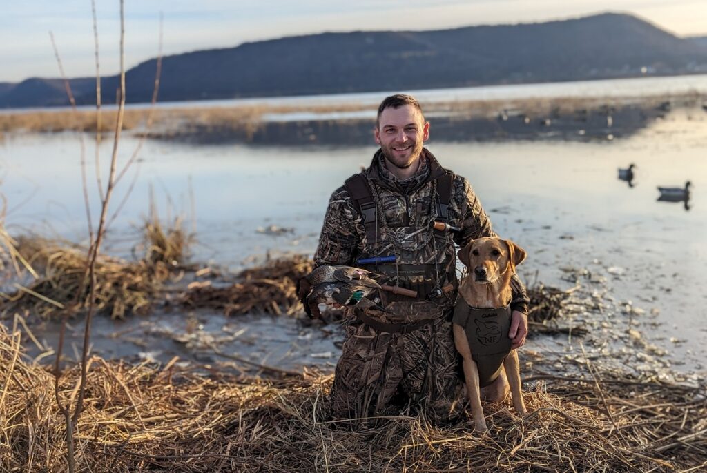 Photo of Cody Kamrowski, UW-Stevens Point '16, with his dog, Nova, working to preserve outdoor habitats.