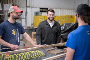 Photo of UW-Green Bay alumnus Michael Becker speaking with co-workers at the Central Wisconsin Woodworking Corporation in Wausau, Wisconsin. Photos by Dan Moore, University Photographer
