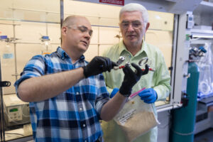Photo of Scientists Steve Karlen and Vitaliy Tymokhin look over a reactor they used for their research on converting biomass into paracetamol.