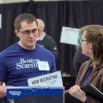 Photo of a UW-Stout student meeting with a recruiter from Boston Scientific at the Spring Career Conference. Recent graduates reported a $58,000 average salary and 99% employment rate. / UW-Stout