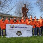 Photo of members of the Conquerors Football Club pictured at the UWSP at Marshfield campus with Chancellor Thomas Gibson (left) and Campus Executive Tony Andrews (right).