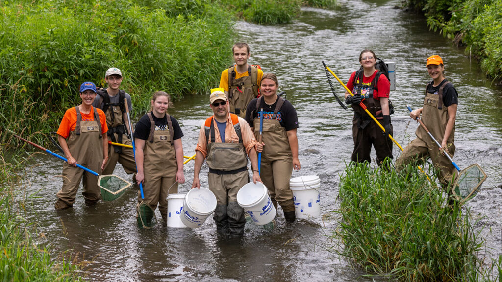 Photo of Dr. Kristopher Wright taking his students and the Chancellor and Provost into the Rountree Branch Stream.