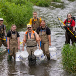 Photo of Dr. Kristopher Wright taking his students and the Chancellor and Provost into the Rountree Branch Stream.