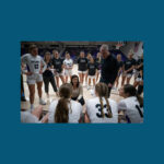 Photo of head women's basketball coach Keri Carollo, center, and her husband Joe, an assistant, talking to players. Their daughter Kacie, right, is among the players. The Warhawk women's basketball team defeated UW-Stevens Point, 53-44, on Jan. 10, 2024, in Kachel Gym. With the win, the Warhawks matched their best start in program history with 14 wins and no losses. (UW-Whitewater photo/Craig Schreiner)
