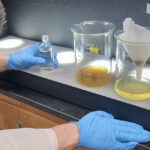 Photo of UW-Oshkosh student Tyler Peskie analyzing water samples for Sadoff Iron & Metal Company