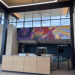 Photo of a brightly colored mural hanging in the lobby of the new Jonathan Delagrave Youth Development & Care Center based in the Village of Caledonia in Racine County. (UW-Parkside)