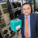 Photo of Deyang Qu, professor of mechanical engineering at UWM, holding a lithium iron phosphate battery, one of many needed to power electric vehicles. He has developed a strategy to recycle the retired batteries to create an economic opportunity. (UWM Photo/Troye Fox)