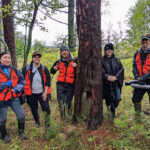 Photo of authors Valerie Zhaawendaagozikwe, Ashla Ojibway, Mocha Reynolds, Emily Lockling, and Evan Larson in the field on Minnesota Point, gathered around a culturally modified old-growth red pine tree.