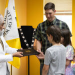Photo: UW-Oshkosh Chancellor Manohar Singh hands a diploma to Barry Moodie, as his children Emmett and Kate and his late wife’s mother, Mary Altenburg, look on.