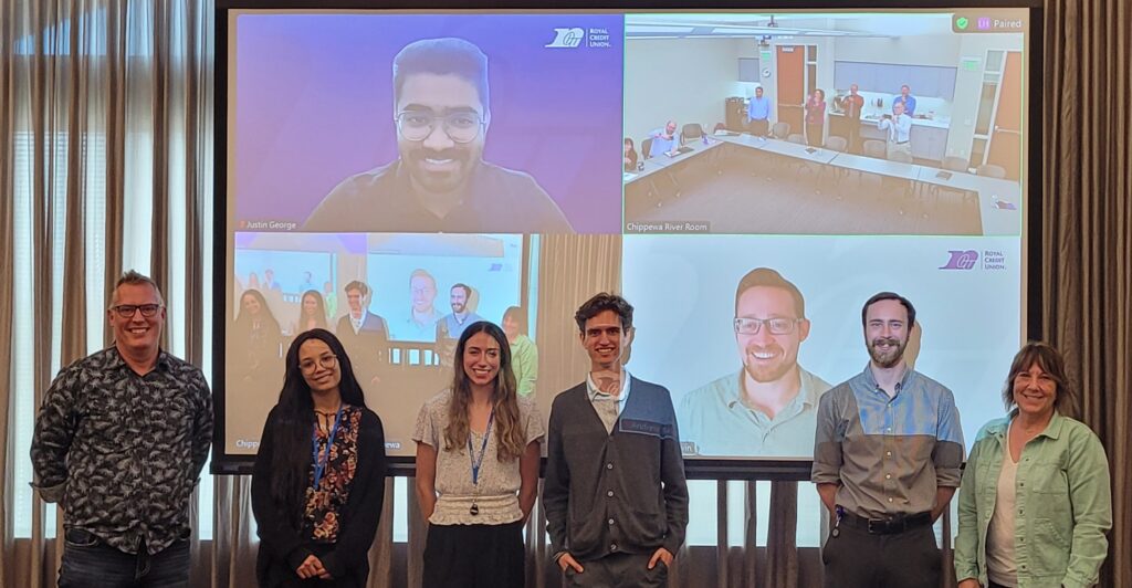 Photo: From left to right:1. Tad Carlson, Royal VP of Information Technology 2. Mariah Waslie of UW-River Falls 3. Paige Keller of UW-Eau Claire 4. Emmett Jaakkola of UW-Stout 5. Matthew Peplinski of UW-Stout 6. Linda Kampa, Royal Senior Date Engineer Upper Left (Screen): UW-Stout graduate student Justin George Bottom Right (Screen): Andrew Baldwin, Royal Senior Business Intelligence Analyst 