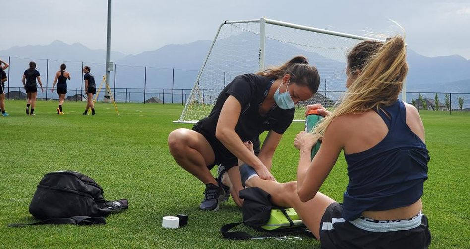 UW Oshkosh alumna Lindsey Toman, athletic trainer, adjusts during COVID