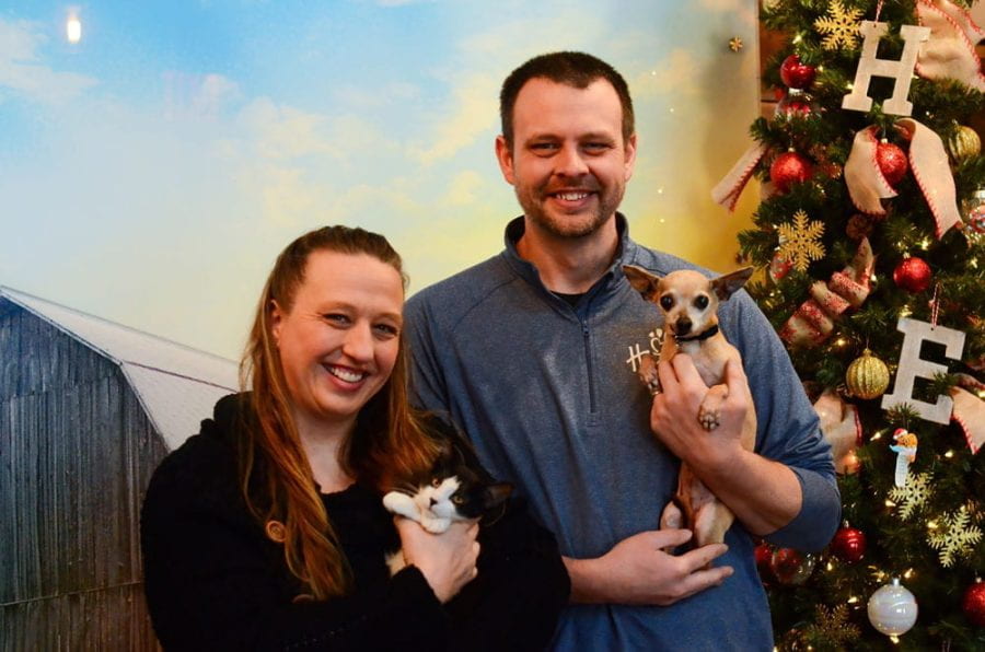 Photo of UW-Green Bay alumni siblings Amanda Reitz and Marcus Reitz posing with a cat and dog at Happily Ever After Animal Sanctuary (HEA) in Green Bay, Wis., on Dec. 4, 2023. Amanda founded HEA in 2006 while still a student, and Marcus joined as director of branding and development in 2015. (Photo by Joey Prestley / UW-Green Bay)