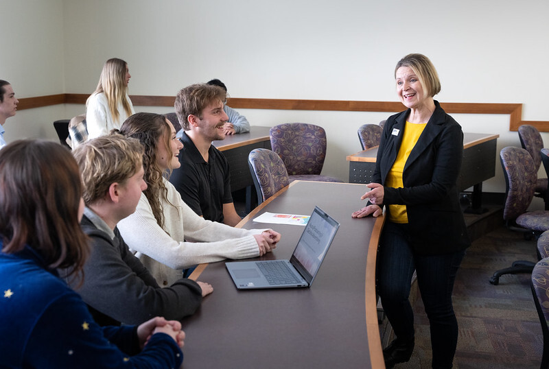 Photo of Teaching Assistant Professor Kathy Fredrickson talking with students from the team that developed the TouchTunes activation idea for Carbliss during UW-Oshkosh’s Advertising Media (AMP 353) course. Pictured with her, from left, are students Brianna Hone, Jacob Link, Jayden Hawkins and Kenny Satori.