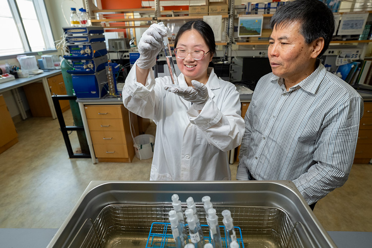 Photo: Jena Choi, a freshwater sciences major, works alongside faculty mentor Laodong Guo to analyze the chemical properties of wastewater that collects in oil fields. (UWM Photo/Andy Manis)