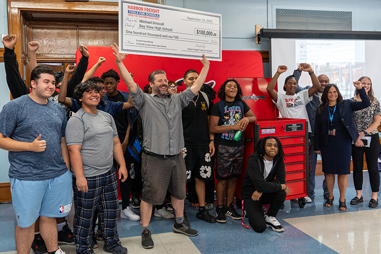 Photo: Mike Driscoll, a Peck School of the Arts alum and teacher at Bay View High School, holds an oversized check above his head surrounded by students and colleagues. (Photo courtesy of Milwaukee Public Schools)