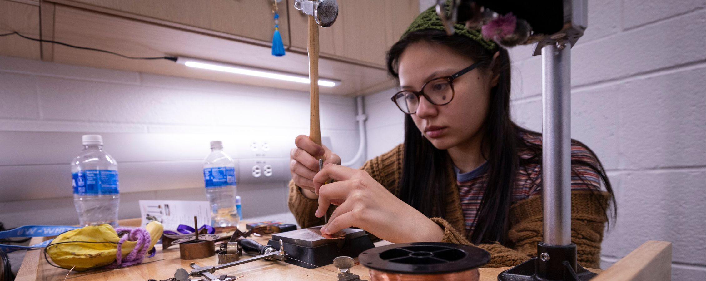 Photo of Liina Heikkinen, a UW-Whitewater art student from Madison, in the metals studio at the Greenhill Center of the Arts with a piece she created on Feb. 3, 2026.