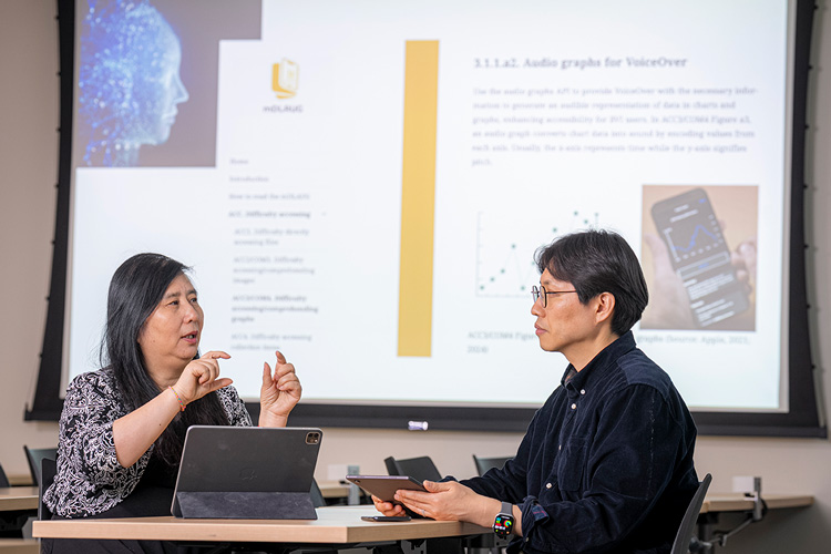 Photo: Iris Xie (left) and Wonchan Choi (right), both faculty members in UWM's School of Information Studies, discuss their project to build new research-driven design guidelines for digital libraries. The effort could help more than 50 million people in the U.S. with visual impairments. (UWM Photo/Andy Manis)