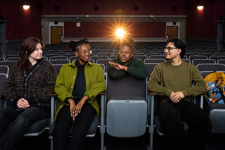 Photo: UWM Assistant Professor Marquise Mays (back) talks with students (from left) Sophie Hatton, Ayanna Jones and Jacob Solis at the Union Cinema. (UWM Photo/Elora Hennessey)