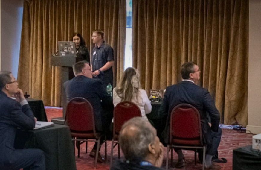Photo of UW-Stout Polytechnic Professor Holly Yuan and Instructor Brandon Cross making their pitch during the Department of War’s Aligned Skills Curriculum and Experiential Network Design (ASCEND) Challenge in Pittsburgh in May. / Submitted photo