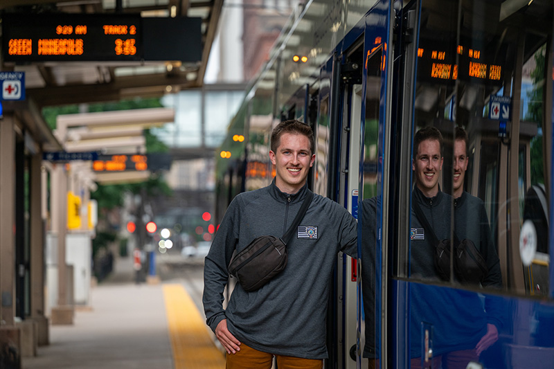 Photo: 2025 UW-River Falls graduate Sasha Resig stands at the Union Depot rail station in St. Paul, Minn. Since earning a triple-major bachelor’s degree in international studies, geography and Spanish, Resig has worked as an intern at the Metro Transit Police Department while pursuing a master’s degree in geographic information science at the University of Minnesota. UWRF photo.