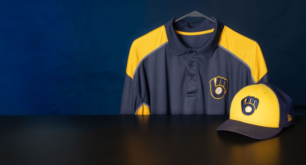 Photo: The polo shirt shows the original 1977 logo created by UW-Eau Claire alumnus Tom Meindel. The baseball cap shows the newer, slightly adjusted logo in use since 2020.