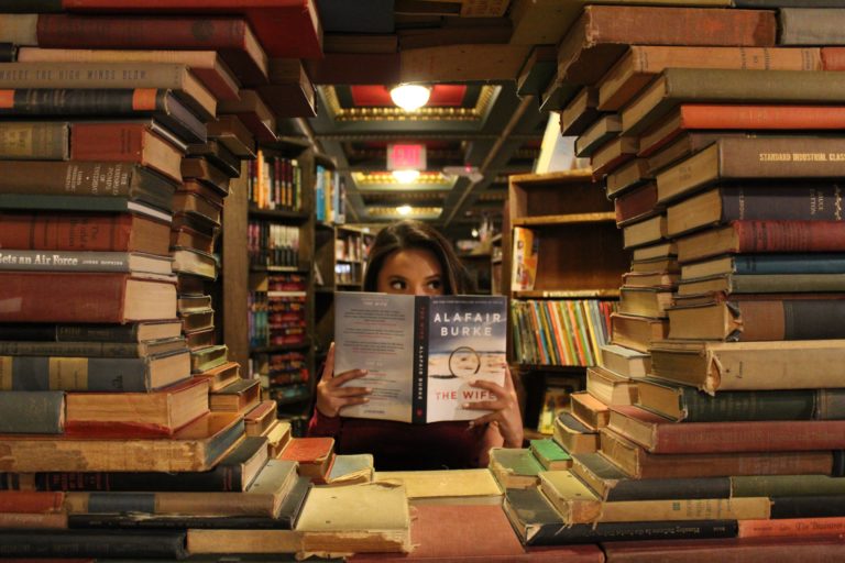 woman in the middle of stack of books