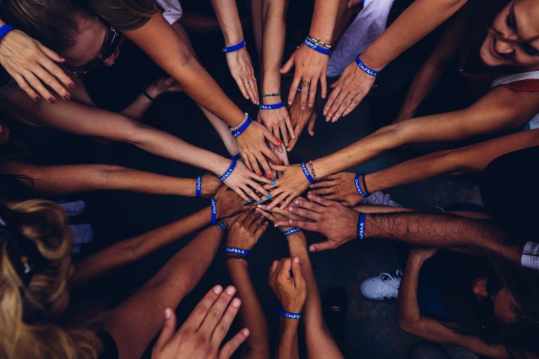 Several hands joined in a circle