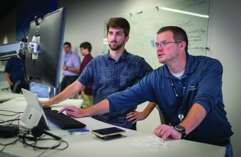 Photo of Matt Kleine (left), who was among the first to begin working at the Sentry IT Co-op with manager Steve Fox. A December graduate of UW-Stevens Point, Matt is now a full-time associate with Sentry Insurance. (UW-Stevens Point photo)