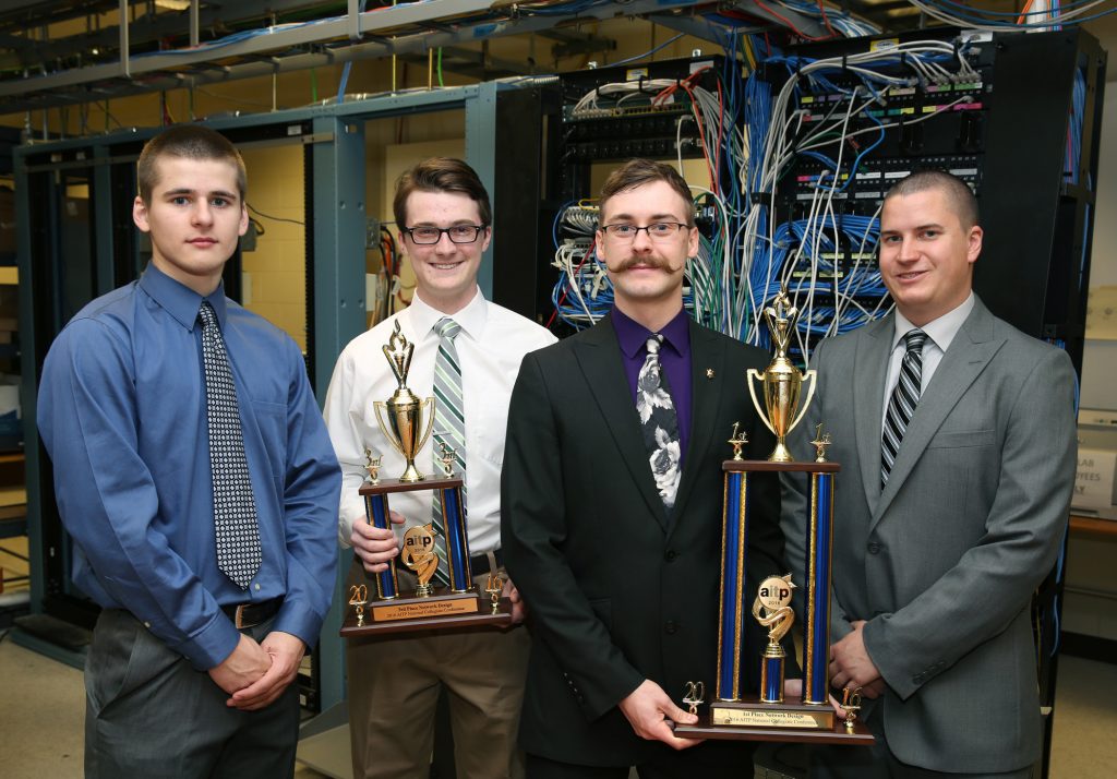 From left, UW-Stout students who placed in a national computer network design contest are Nathanael Satnik and Corey Schoff, third place; and Dan Schmidt and Brandon Wolf, first place. They hold their trophies in a computer networking lab in Fryklund Hall.