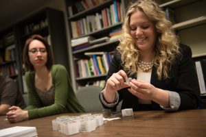 Social work students Joyce Idárraga, left, and Alissa Peanasky, right, look at the iPods they used for their research project examining the impact of personalized music on dementia caregivers.