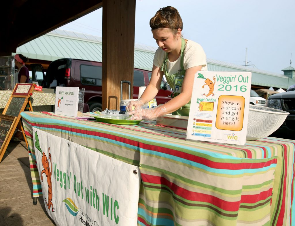 Amanda Nass, a UW-Stout dietetics student, puts out samples at the Veggin’ Out booth at the Downtown Farmers’ Market in Eau Claire.