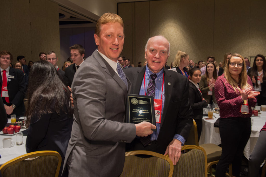 UW-Stout Professor Phil McGuirk, right, receives a plaque in February in Orlando for 40 years of service to the Club Managers Association of America. Presenting the award is Randy Ruder, a UW-Stout alumnus and a member of the CMAA Board of Directors.