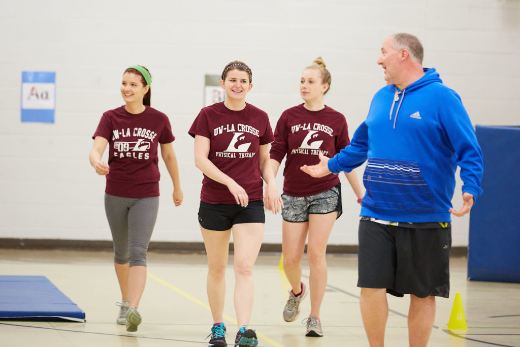 Physical Therapy graduate students, from left, Brenna Dubick, Abigail Bishop and Sydnie Kraus, take a warm up lap with Nicholas O’Keefe, physical education teacher at Summit Elementary School. The three UWL Physical Therapy students designed a fitness program at the La Crosse school along with student Elizabeth Skaer.