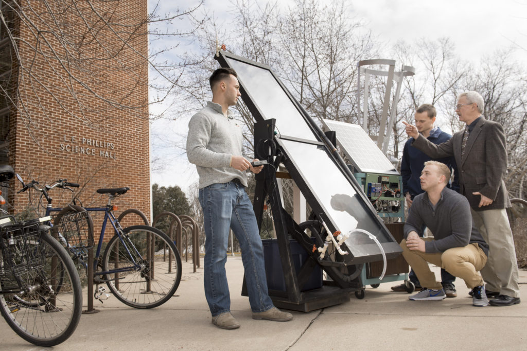 Dr. Kim Pierson, UW-Eau Claire professor of physics, discusses a solar-powered water heater he is developing with research students Brendon Kwick, Sawyer Buck and Hunter Hermes.