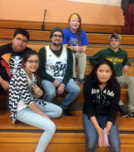 Noelle Metoxen, top, and fellow UW-Stout students Mike Firkins, third from left, and Matt Schmidt, right, take a break in the gym with Lac Courte Oreilles Ojibwe tribal school students.