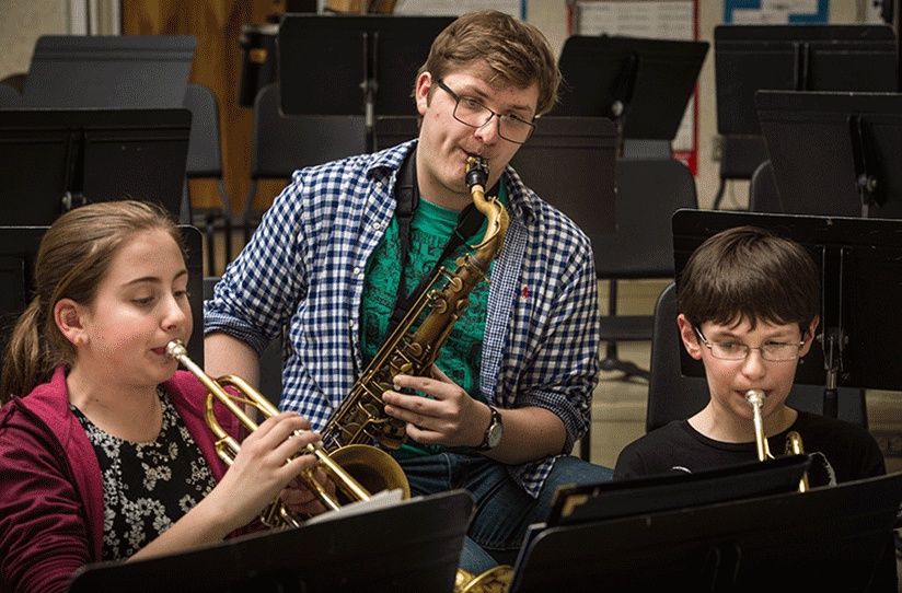 UW-River Falls music education student Kyle Punt, center, practices with Meyer Middle School sixth graders Claire Vaught, left, and Max Pnewski, right, during an afternoon Harmony Bridge session.