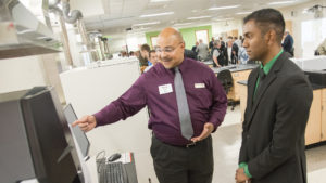 Photo of UW-Parkside pre-med student Siva Shankar of Kenosha talking with Shimadzu Engineer Delano Turner