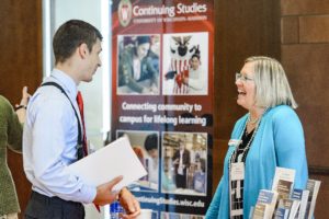 Barbara Nehls-Lowe, senior outreach specialist in the Division of Continuing Studies, talks with one of many corporate representatives, who ranged from human resource managers to CEOs and hailed from regional businesses and global companies. PHOTO: BRYCE RICHTER