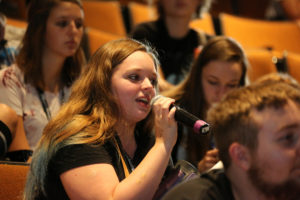Photo of GPS student speaking into microphone