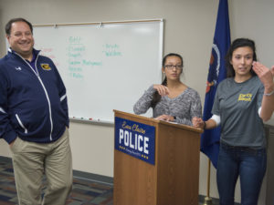 Photo of Dr. Jeff Janot and Blugolds Chantal Bougie and Anna Kohler (from left) talking with Eau Claire police officers about a shared research project.