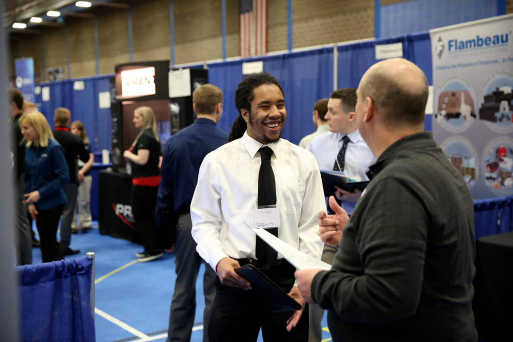 Photo of Jalen Hendley, a computer science-game design major from Flossmoor, Ill., visiting with a recruiter at a 2017 Career Conference. / UW-Stout photo by Brett Roseman