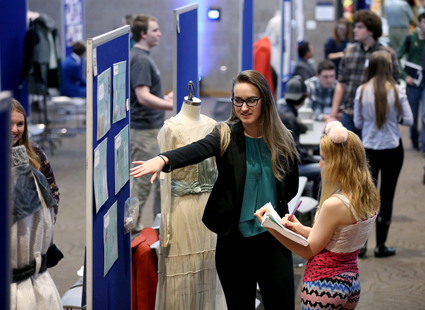 Photo of Sofia VanTassel, an apparel design and development major, explaining her research on the history of clothing at the STEMM Student Expo Dec. 14 at UW-Stout.