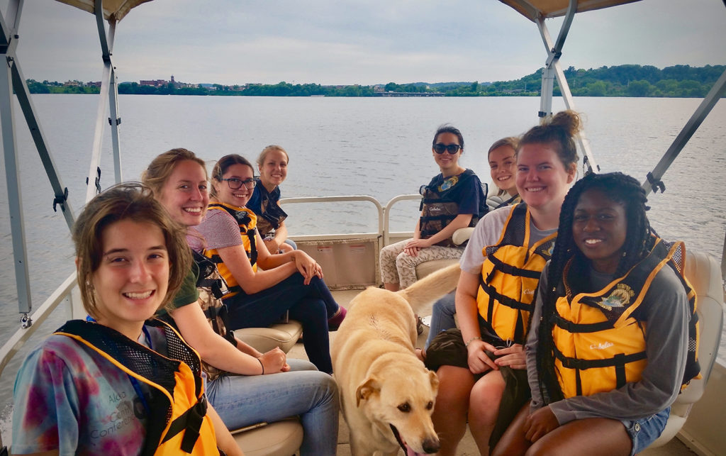 Photo of LAKES REU students taking a pontoon ride on Lake Menomin to learn more about the lake and blue-green algae.