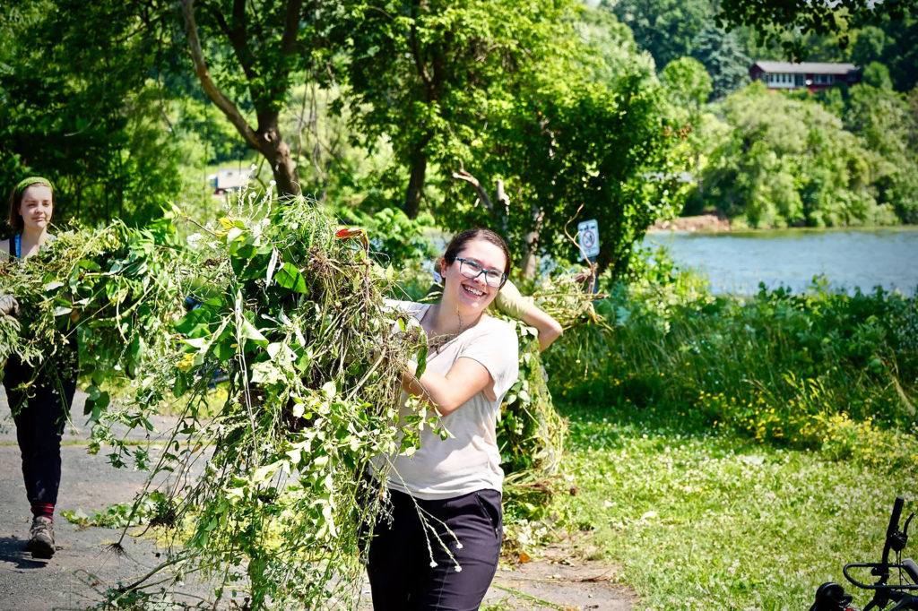 Photo of UW-Stout LAKES REU students helping to weed a rain garden on the shores of Lake Menomin in Menomonie. The eight-week program studies issues related to cyanobacteria, commonly known as blue-green algae, in the Red Cedar watershed and how the compromised water quality affects the area.