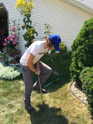 Photo of Carly Ziter collecting soil samples from the front yard of a study participant in Madison to determine the benefits provided by different types of urban green space. Photo by Lauren Jensen