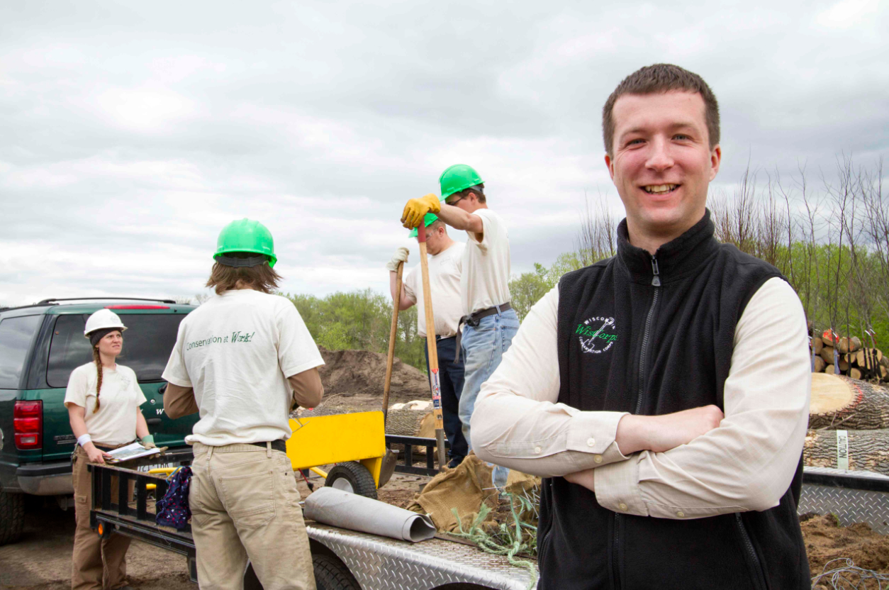 Brantner smiling with a crew working in the field