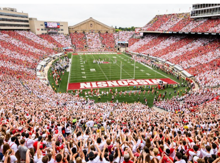 View of a filled Camp Randall football stadium before a football game with fans cheering.